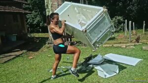 Maria Luiza lifts, toys and destroys a refrigerator