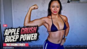 Lidia smashes apples with her strong muscles