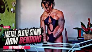 Gil Cunha Bends a Metal Clothing Stand with her Massive Arms